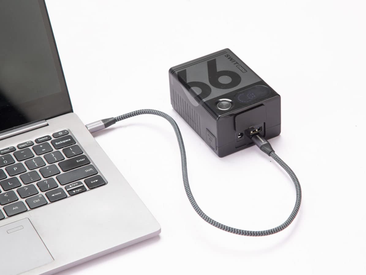 Compact USB-C hub connected to a laptop for expanded connectivity.